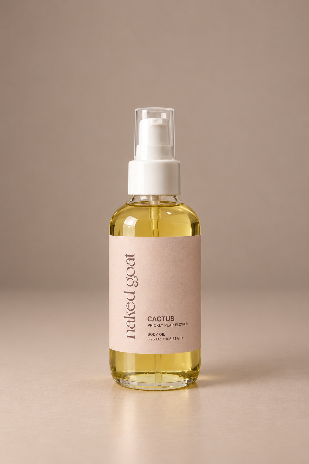 A bottle of Naked Goat Cactus Body Oil with a white treatment pump and a beige label, set against a solid beige background.