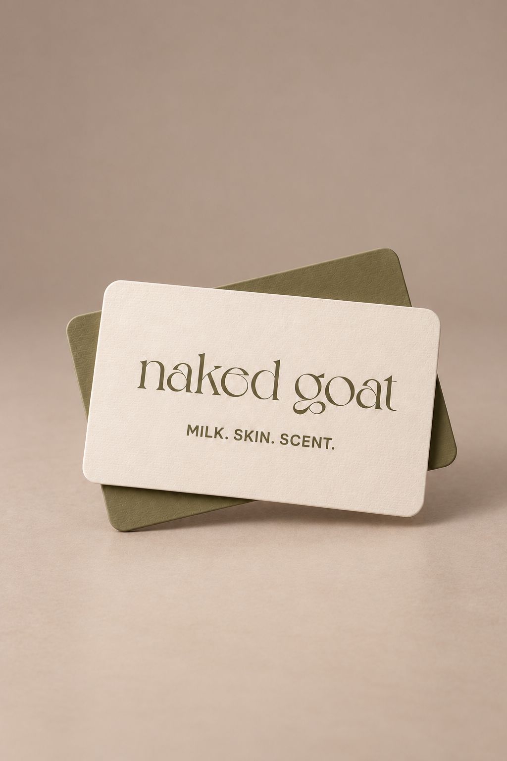 Naked Goat gift card featuring Milk. Skin. Scent. branding on a seamless mushroom studio background.