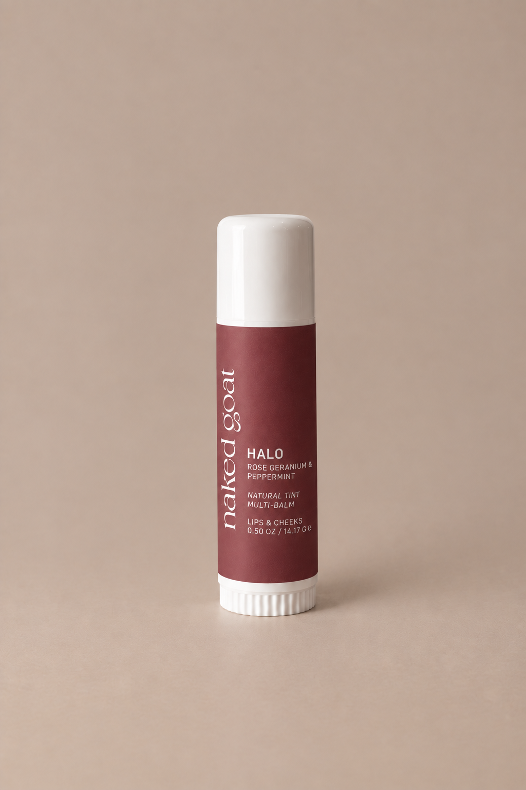 A single tube of Naked Soak Halo lip balm standing upright on a plain beige background. The tube has a white cap and base with a dusty rose-brown label featuring white text.