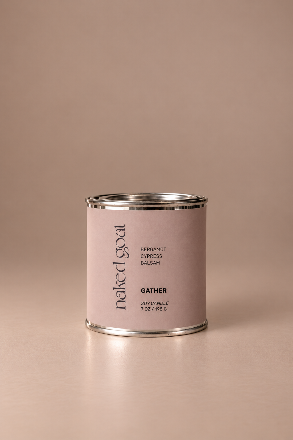 Naked Goat Gather soy candle with bergamot, cypress and balsam on a seamless mushroom studio background.