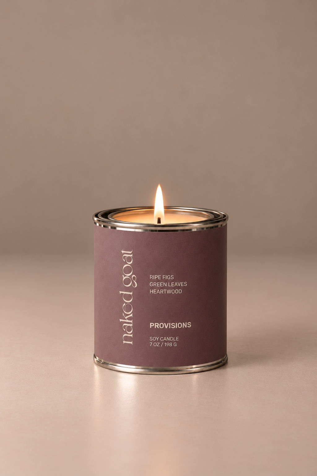 Naked Goat Provisions soy candle with ripe figs, green leaves and heartwood on a seamless mushroom studio background.