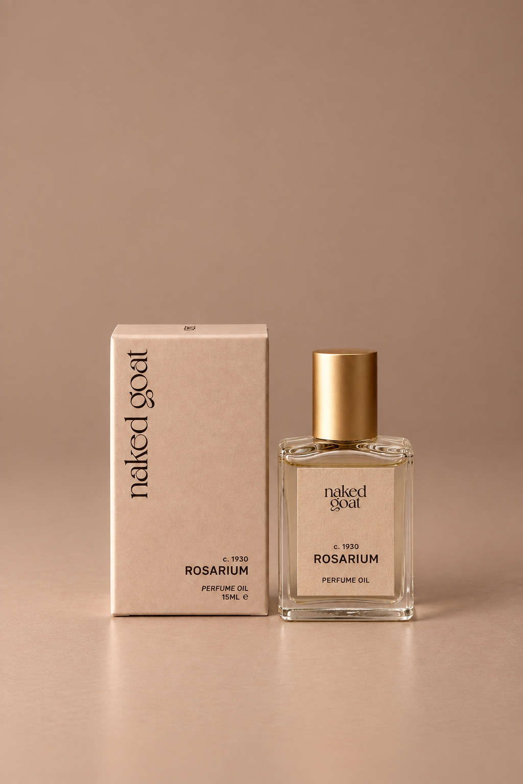 A bottle of Naked Goat Rosarium Perfume Oil next to its matching beige box, set against a solid warm beige background.